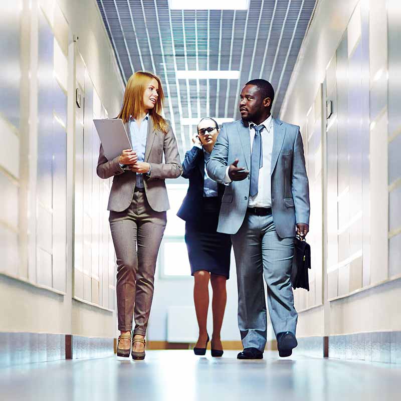 Employees in corridor discussing business protection