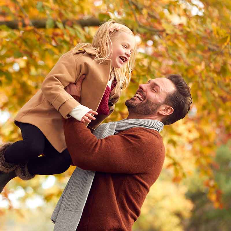 Father playing with daughter outside